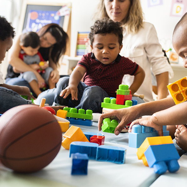 Children playing with blocks with caretakers