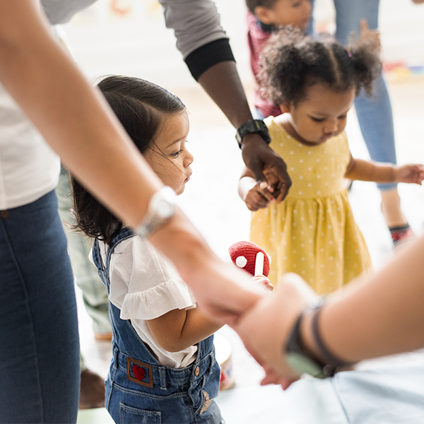 Children and caretakers holding hands