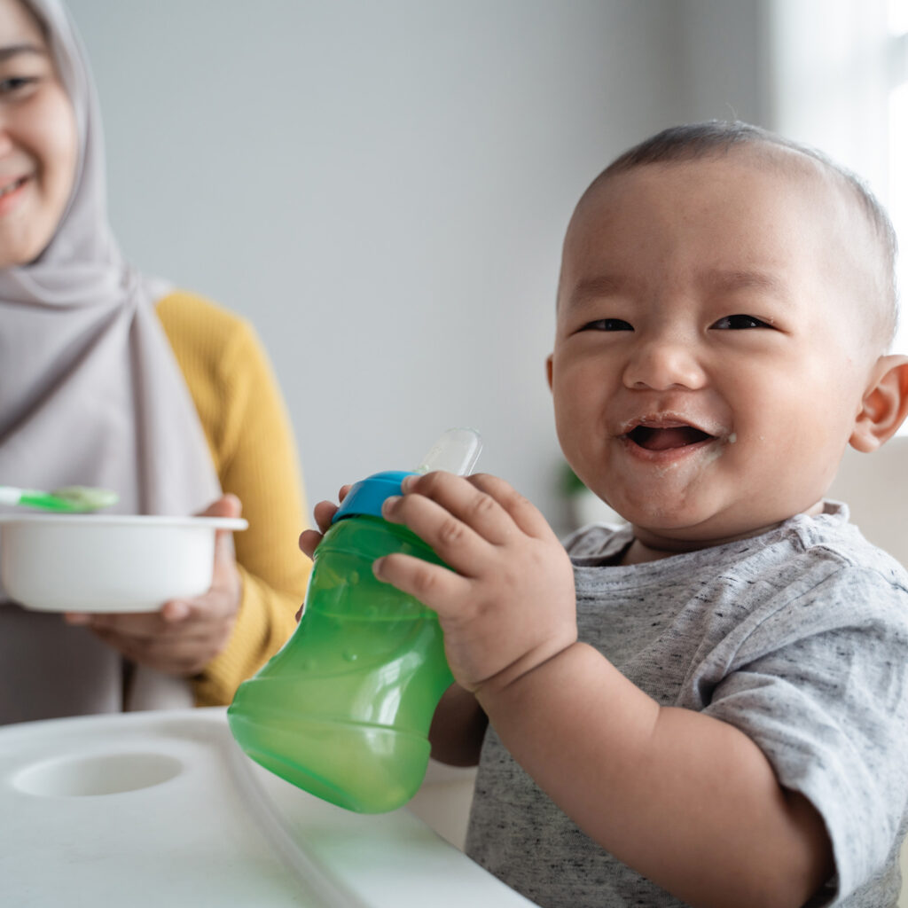 Smiling baby with sippy cup