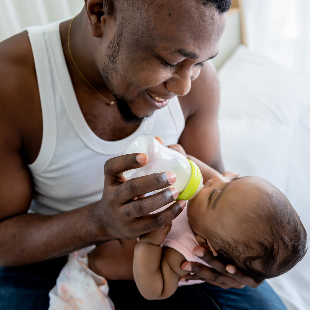 dad feeding baby with bottle